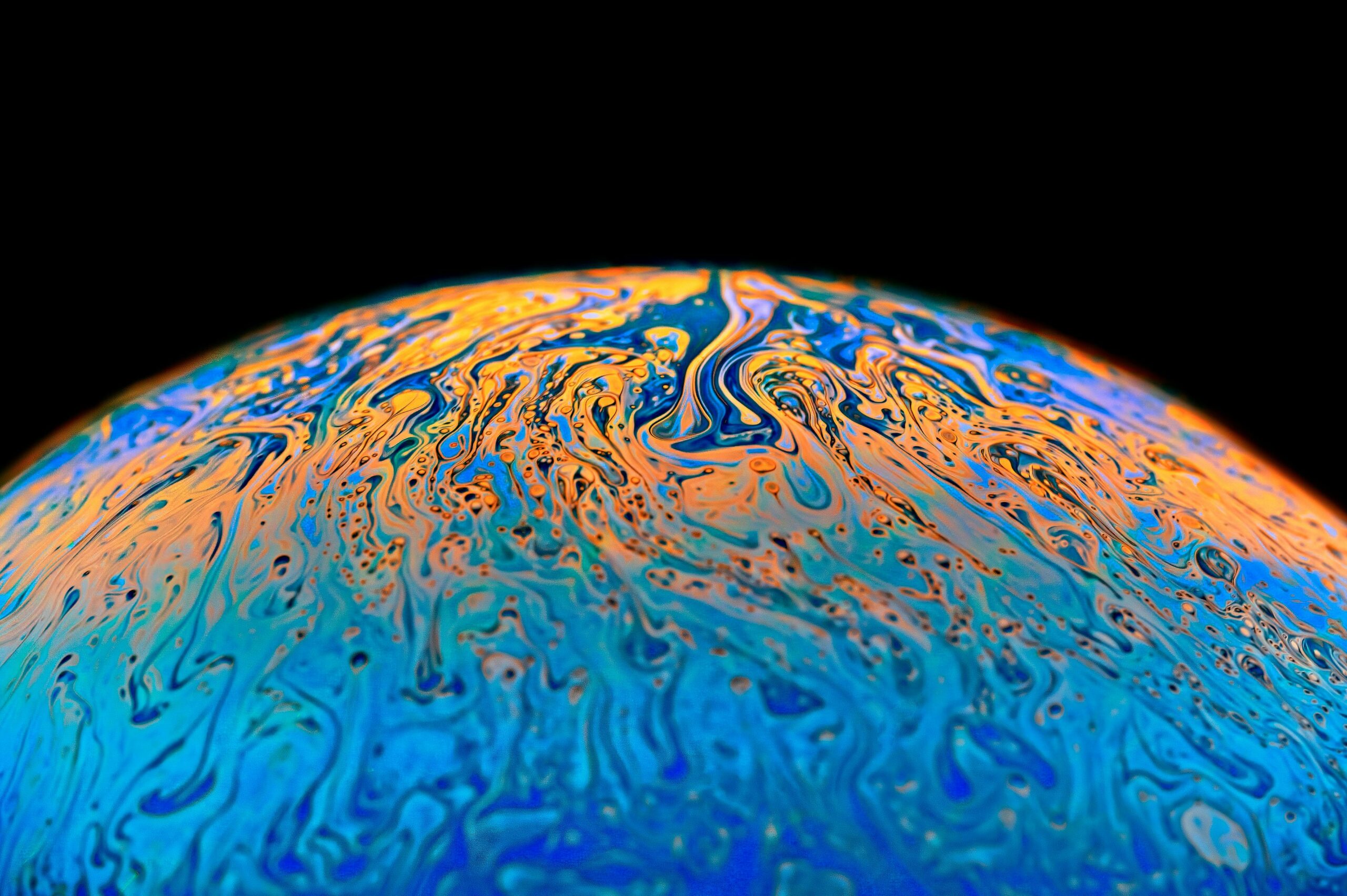 Colorful abstract image resembling a planet with swirling cosmic patterns.