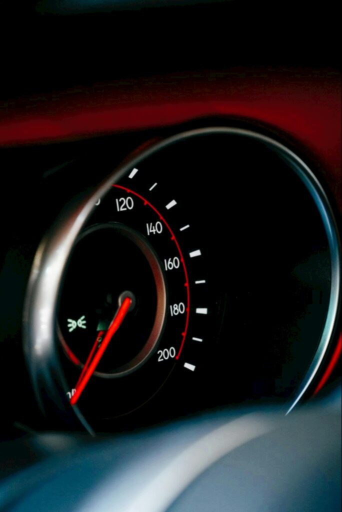 Detailed vertical shot of a classic car speedometer with a focus on its dial.